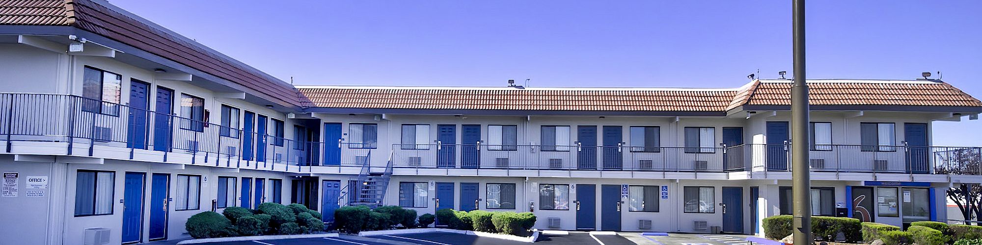 This image shows a two-story motel with a sign featuring a large number 